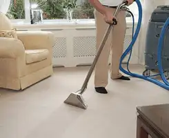 Carpet cleaning professional removing dirt and stains with a hot-water extraction tool in a home, Orlando, FL.