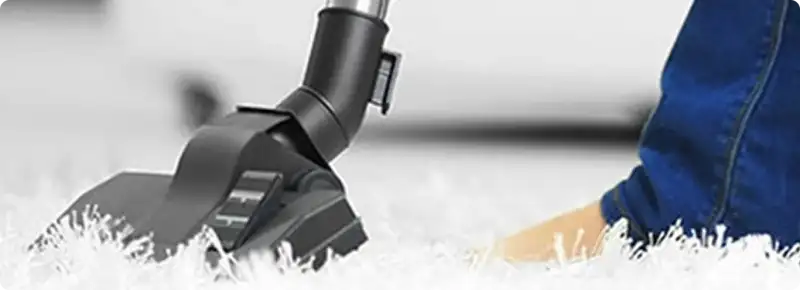 Close-up of a professional vacuuming a white carpet in Winter Park.